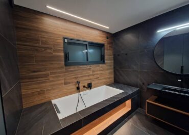 Salle de bain avec baignoire et grand miroir