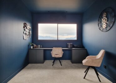 Réalisation d'un espace bureau avec mur bleu, chaises et bureau vu de près